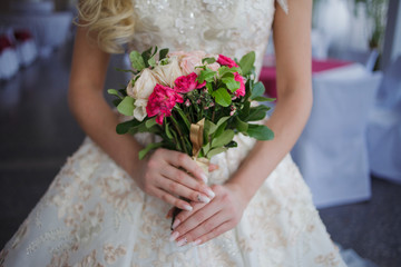 Obraz na płótnie Canvas Bride's bouquet. Beautiful girl in a luxurious wedding dress holding flowers