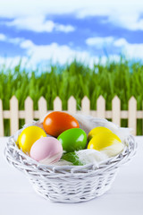 Colored easter eggs in the basket on nature background