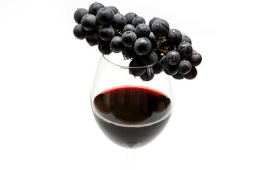 Glass of red wine and grapes isolated on white background