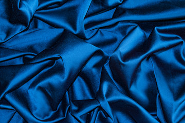 Folds of fabric a dark color satin close-up