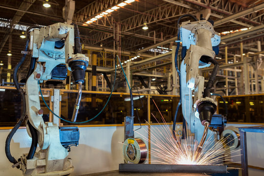 Team robots are welding part in automotive industrial factory
