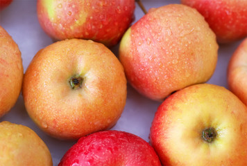 Background with fresh delicious juicy red apples. Delicious colorful sweet-sour apples in the box on the market