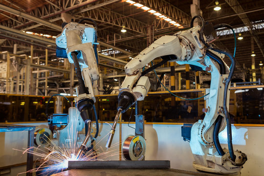 Team robots are welding part in automotive industrial factory