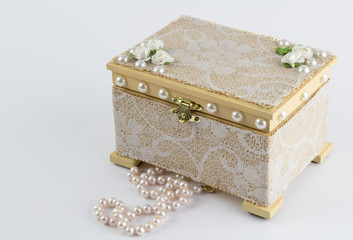 Wood box handcrafted with pink pearl necklace on white