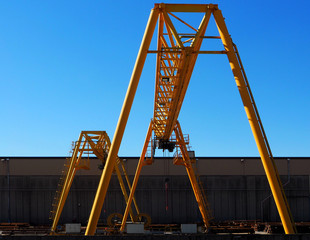 Yellow gantry cranes outside a factory building