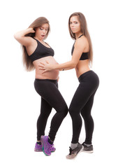 Fototapeta na wymiar Pregnant woman with her twin sister on a white background.