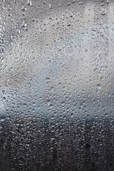 raindrops on window of car and background in shades of blue