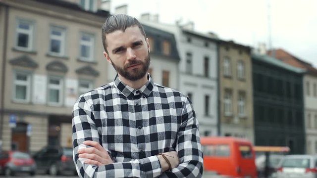 Handsome man in checked shirt holding his arms crossed and doing serious look to the camera
