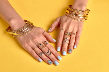 Beautiful female manicure with gold jewelry.