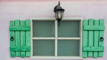 Old wooden window on light pink wall.