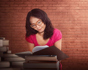 Portrait of a serious young asian woman reading a book