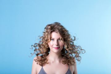 Girl with curly hair on a blue background.