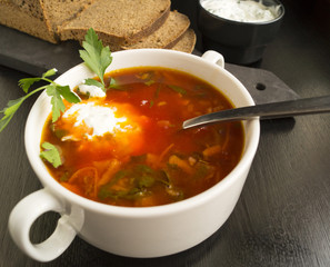 Beet soup in wooden plate with vegetables on wooden table. Borch, traditional Russian food