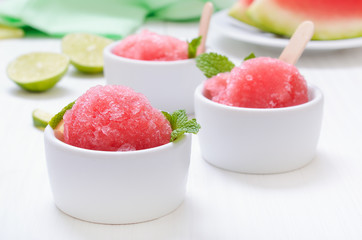 Watermelon sorbet decorated with mint in white bowl