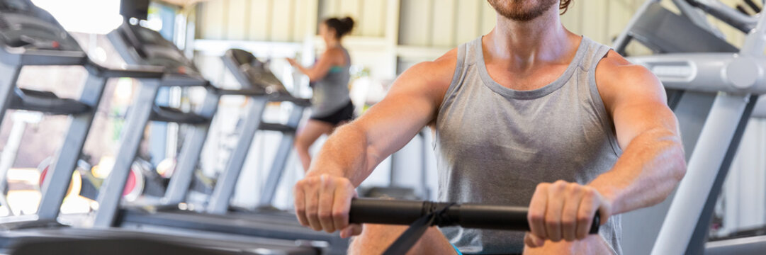 Man Training On Rowing Machine In Fitness Gym