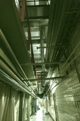 Ceiling in the shop of the production plant with iron pipes