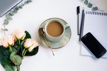 Mother's Day concept.Flat lay, top view office table feminine desk. workspace with laptop, phone, cup of cofee and bouquet pink roses.