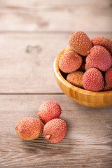 Fruits lychee in a bowl on a wooden background. Selective focus. Copy space.