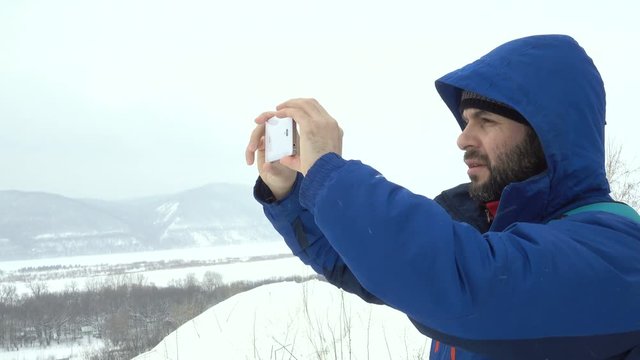 Traveler With a Beard Using Smartphone On Mountain.