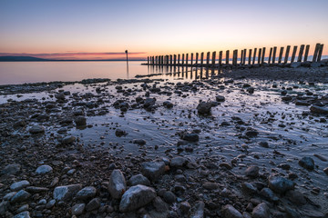 Old quay on a calm lake in the morning before sunset
