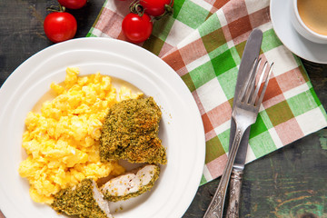 Breakfast - an omelet, chicken fillet in a green breading and coffee on a table. Selective focus. Top view. Copy space.