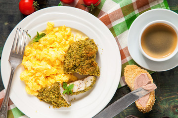 Breakfast - an omelet, chicken fillet in a green breading and coffee on a table. Selective focus. Top view. Copy space.
