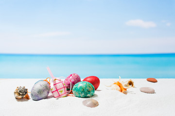 Fototapeta na wymiar Easter on tropical beach background. Eggs on the white sand. Vacation and travel concept