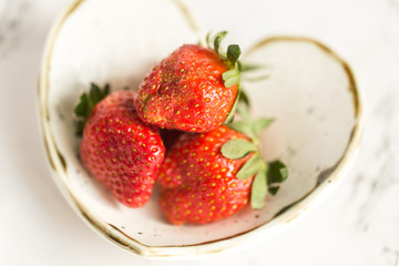 Fresh strawberries in heart-shaped pottery