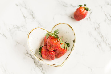 Fresh strawberries in heart-shaped pottery