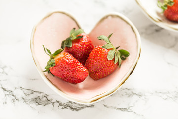 Fresh strawberries in heart-shaped pottery