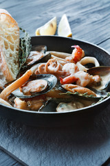 Seafood Stew in Saucepan on dark wood background
