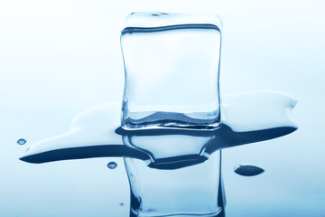 Melting ice cube with reflection isolated on white.