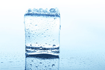 Transparent ice cube with reflection isolated on white.