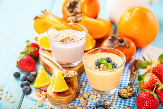Orange persimmon blueberry smoothie with granola  and fruits. Selective focus. Copy space