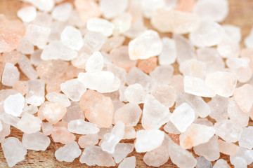 Pink Himalayan salt crystals on wooden background