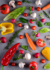 Healthy food concept. Studio photography of different vegetables and greenery on a grey background. Top view. Vertical food background.