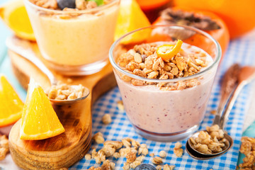 Orange persimmon blueberry smoothie with granola  and fruits. Selective focus. Copy space