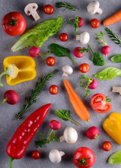 Healthy food concept. Studio photography of different vegetables and greenery on a grey background. Top view. Vertical food background.