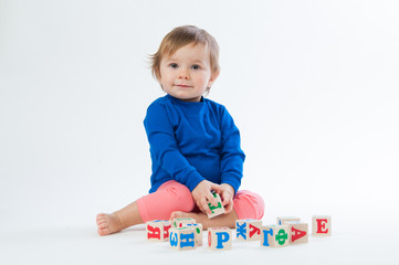 Little child playing with dices isolated on white background