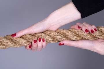 Woman's hands with painted nails gripping a rope