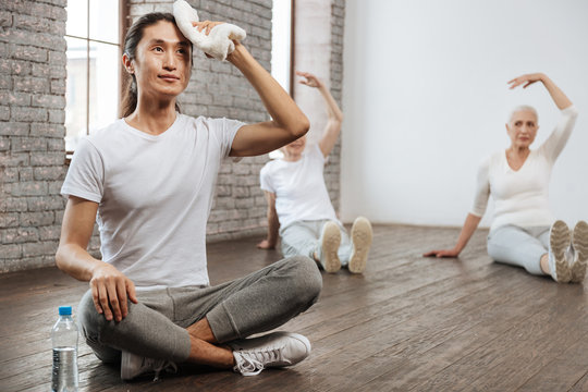 Asian tutor sitting in yoga pose on the floor