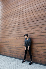 girl in a black leather jacket near the wooden wall