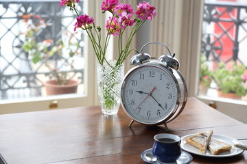 Retro clock with flowers on antique table