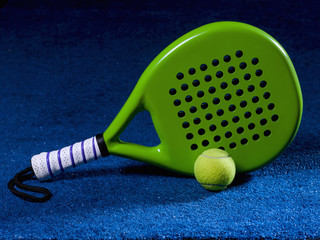 Paddle racket, next to the ball and on a carpet of the play area.