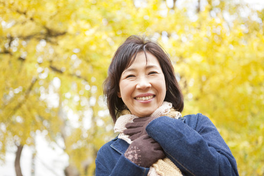 Mature Woman Walking In the Woods In Autumn