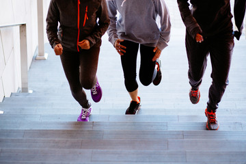 Group of three fitness woman running up on the stairs