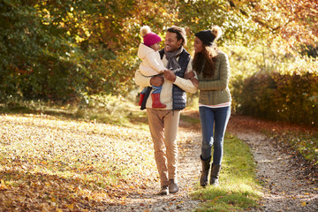 Family With Young Daughter Enjoying Autumn Countryside Walk