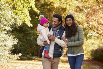 Family With Young Daughter Enjoying Autumn Countryside Walk