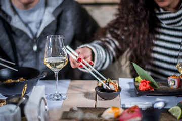 Hands eat sushi with chopsticks