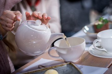 The girl pours tea in a white mug - 140462537